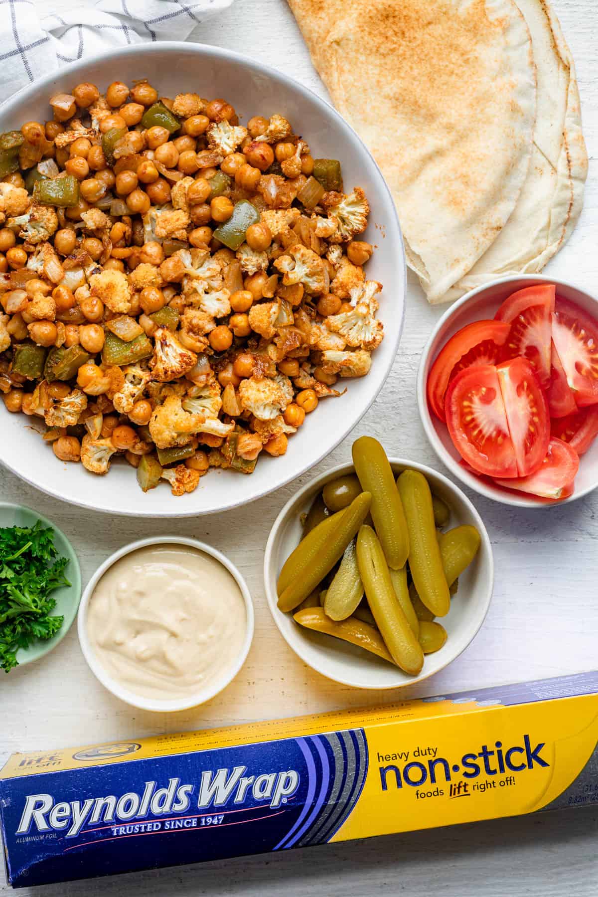 Chickpea shawarma bowl with all the toppings around and Reynolds wrap nonstick foil