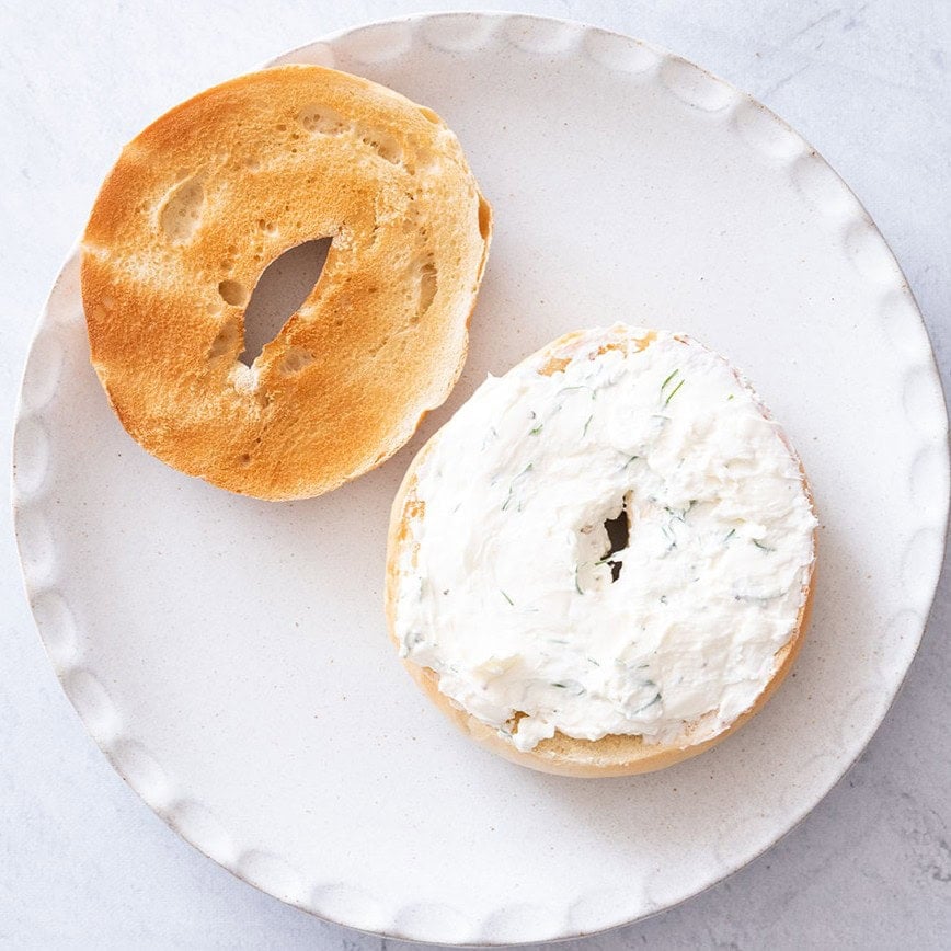 Cream cheese mixture spread on one half of a bagel.