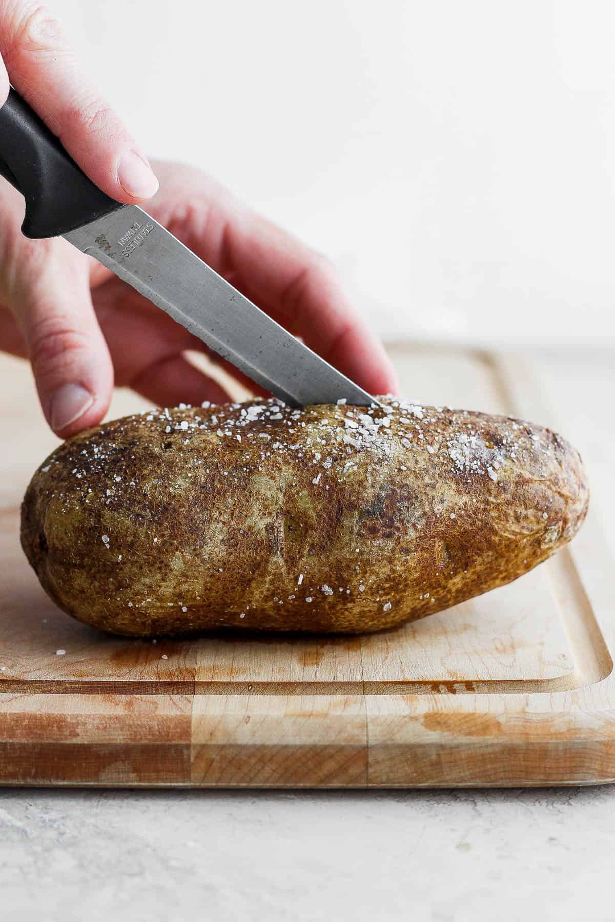 Slicing baked potato in half after baking