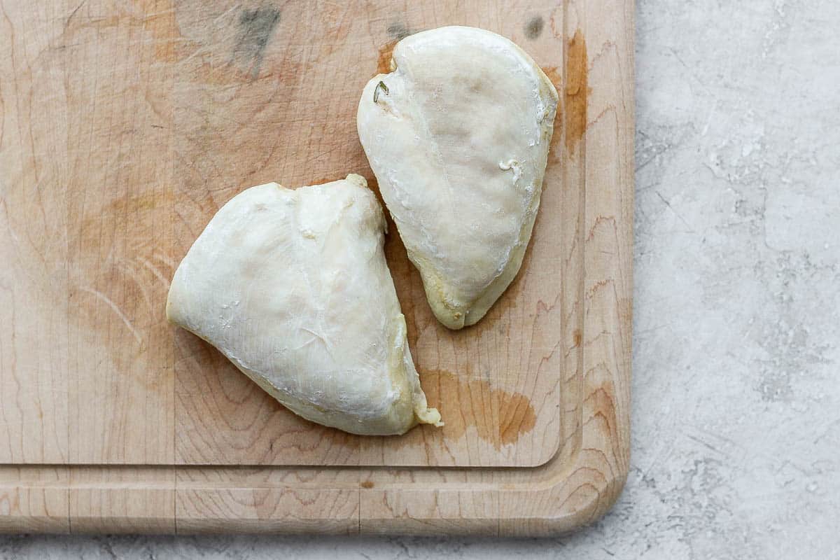 Poached chicken resting on cutting board