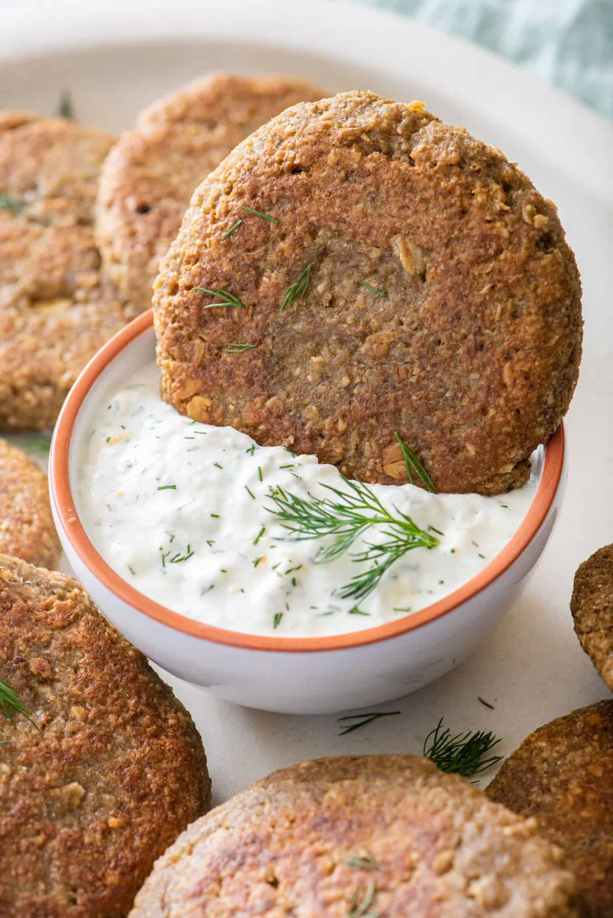 Lentil cake dipping into yogurt sauce