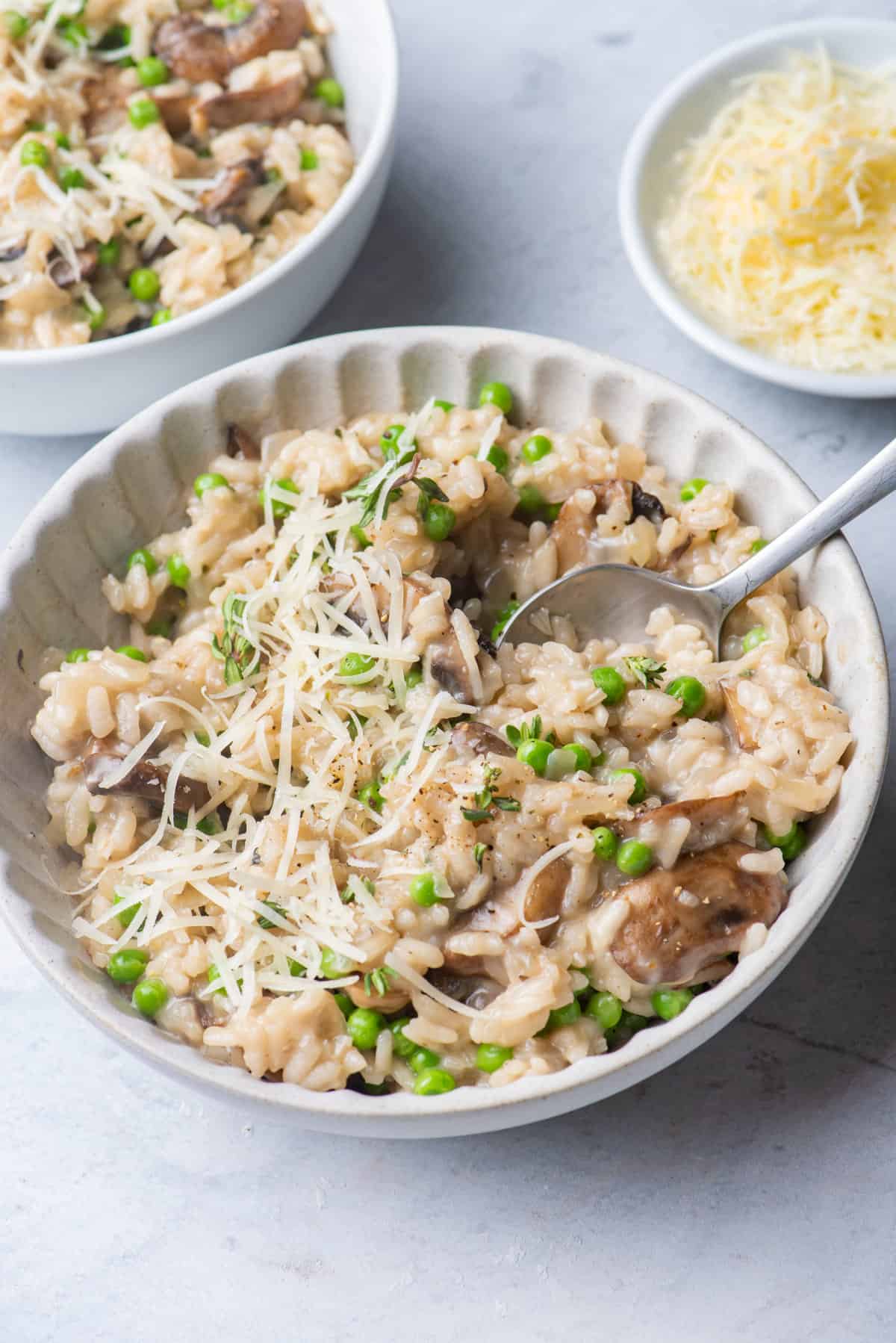 Bowl of mushroom peas risotto with spoon inside