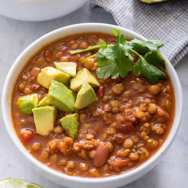 Two bowls of vegan lentil chili with avocado