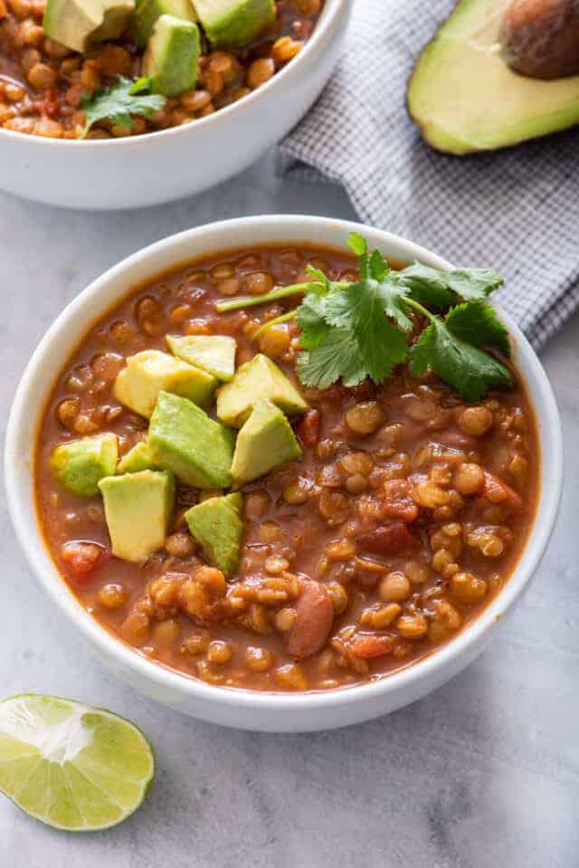 Two bowls of vegan lentil chili with avocado