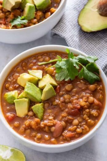 Two bowls of vegan lentil chili with avocado