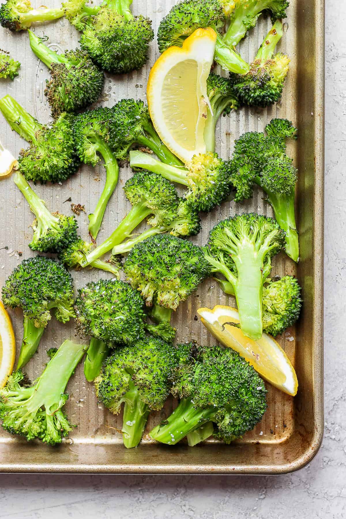 Oven roasted broccoli on tray with lemons