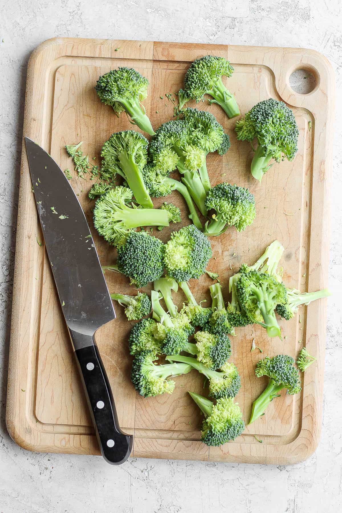 Broccoli florets on cutting board with knife