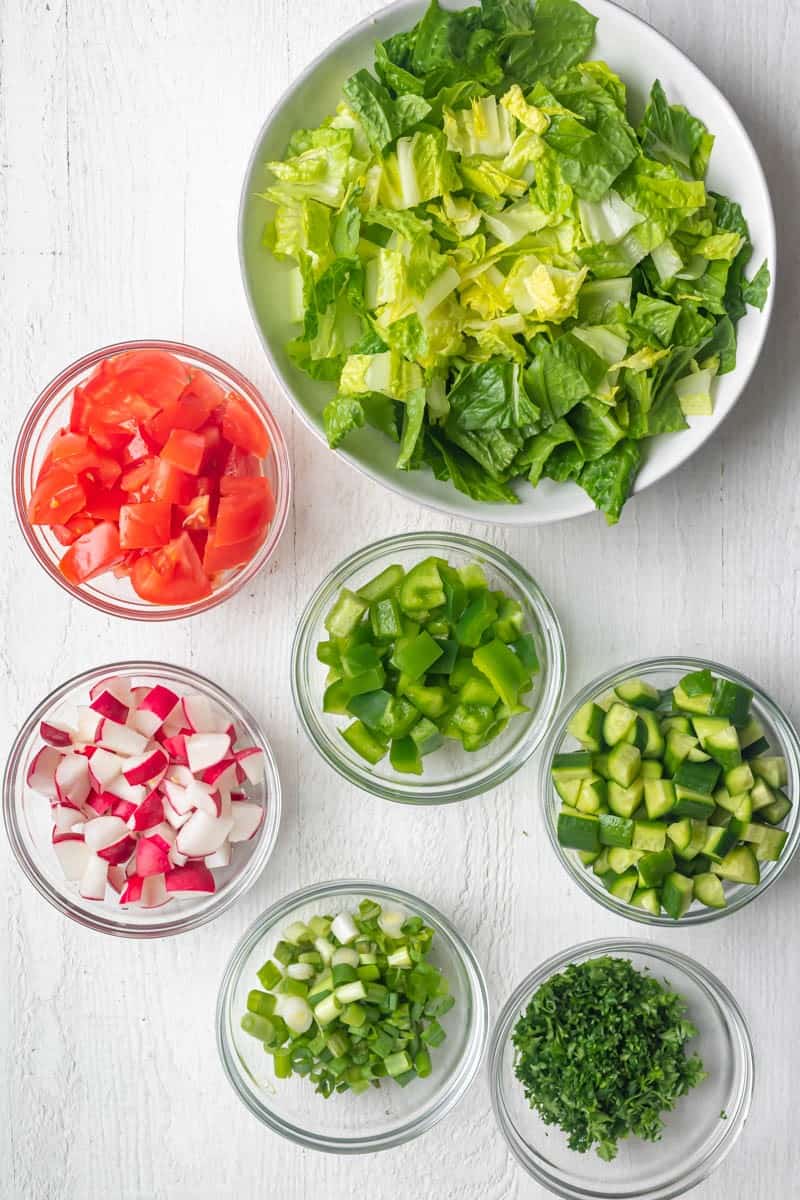Ingredients for the salad chopped and put in separate bowls.