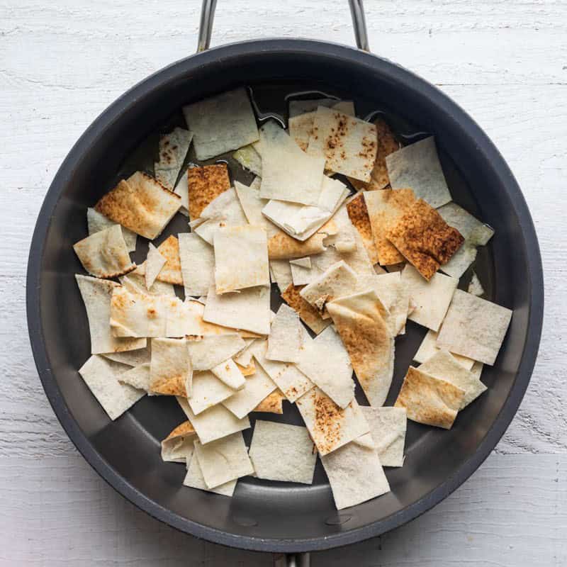 Pita bread in a pan before toasted on the stove.