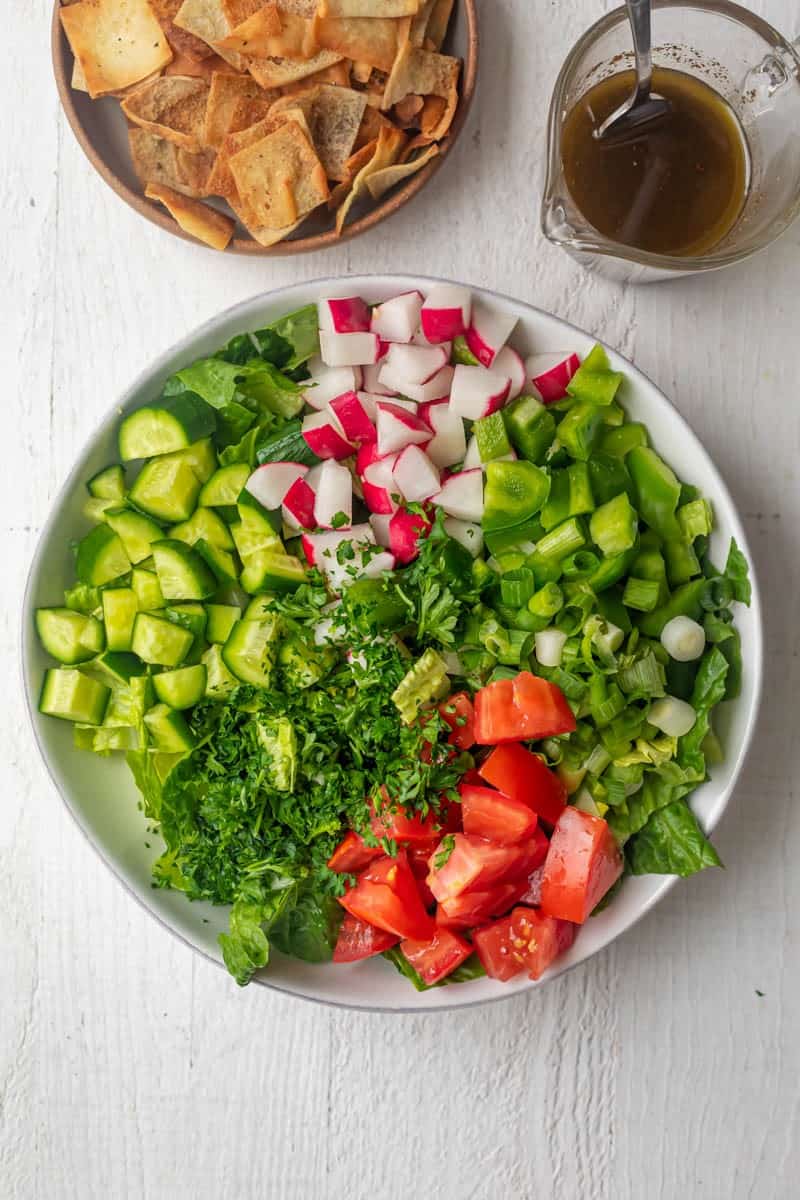 Chopped salad ingredients in a bowl before mixing or adding the dressing.