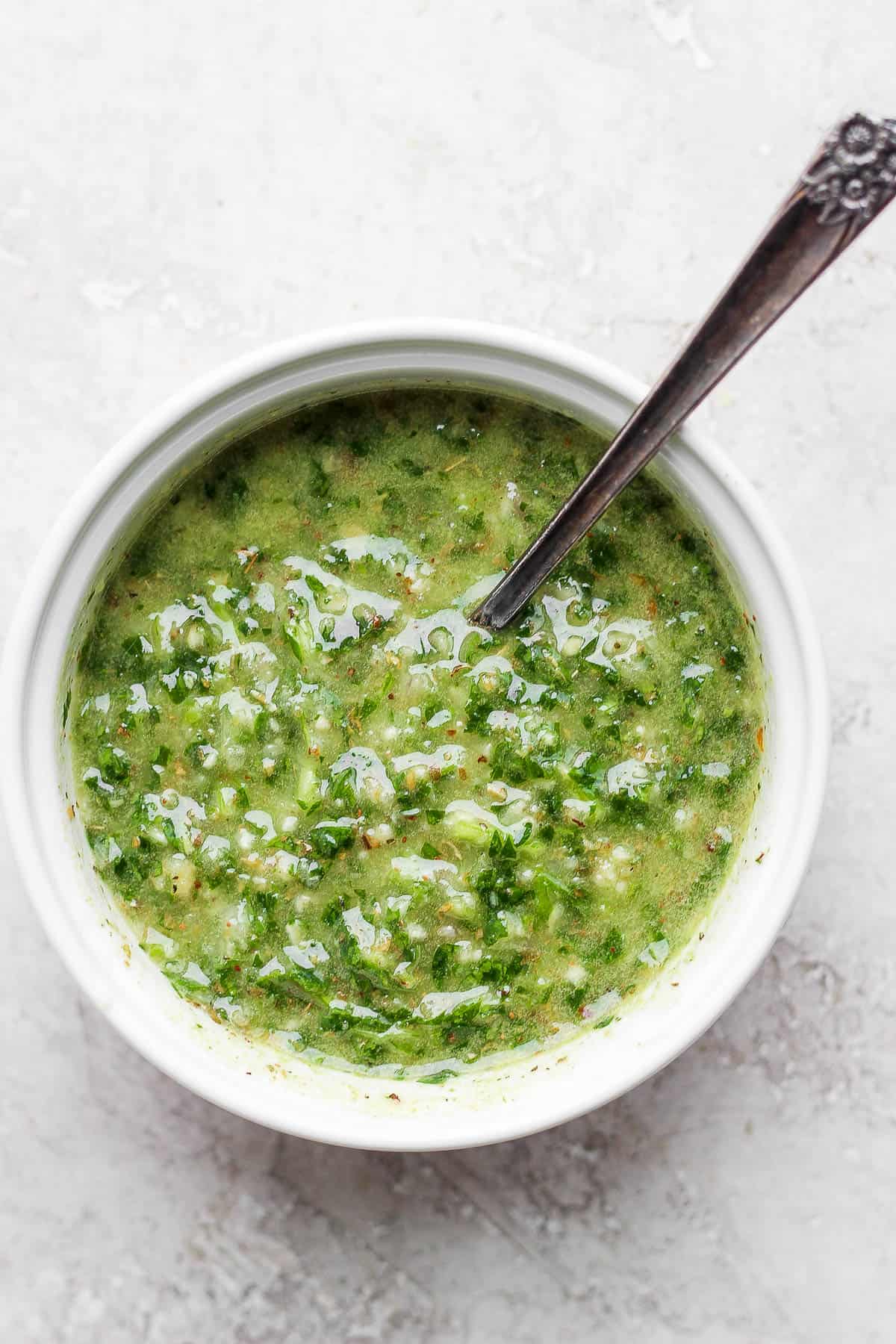 Chimichurri sauce in a small bowl with a spoon