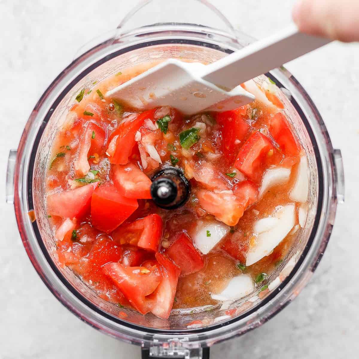 Ingredients in food processor roughly chopped with spatula scraping down the sides.