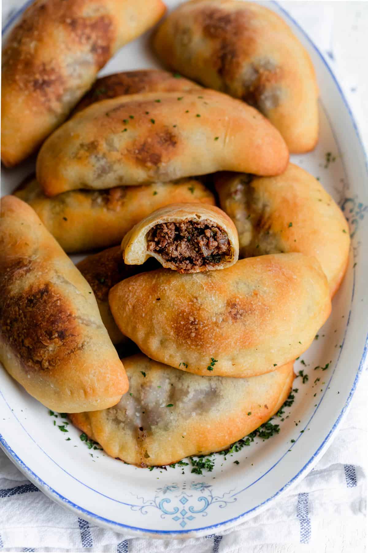Lebanese sfeehas meat pies with one cut open to show filling