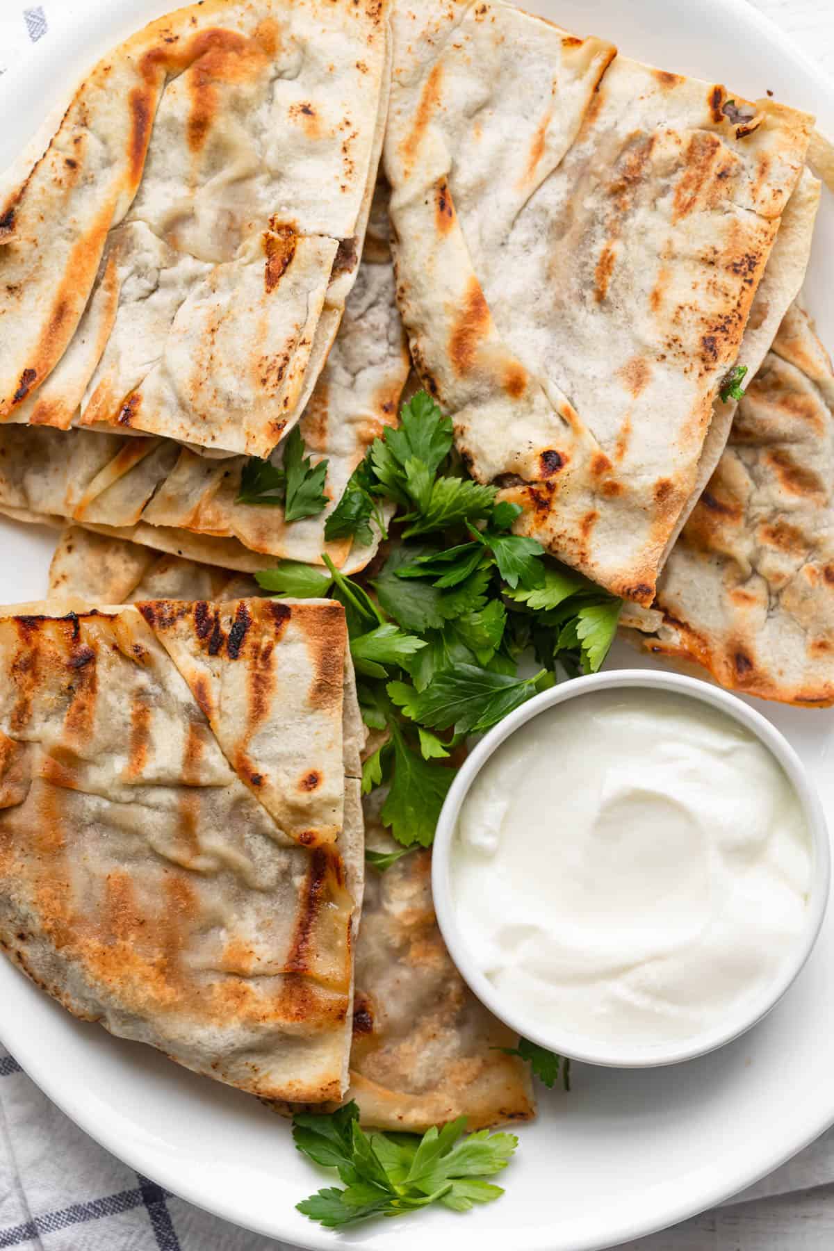 Final serving of the meat stuffed pitas (arayes) with yogurt and parsley