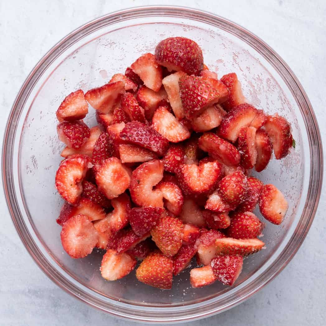 Strawberries in bowl after tossed with lemon and sugar.
