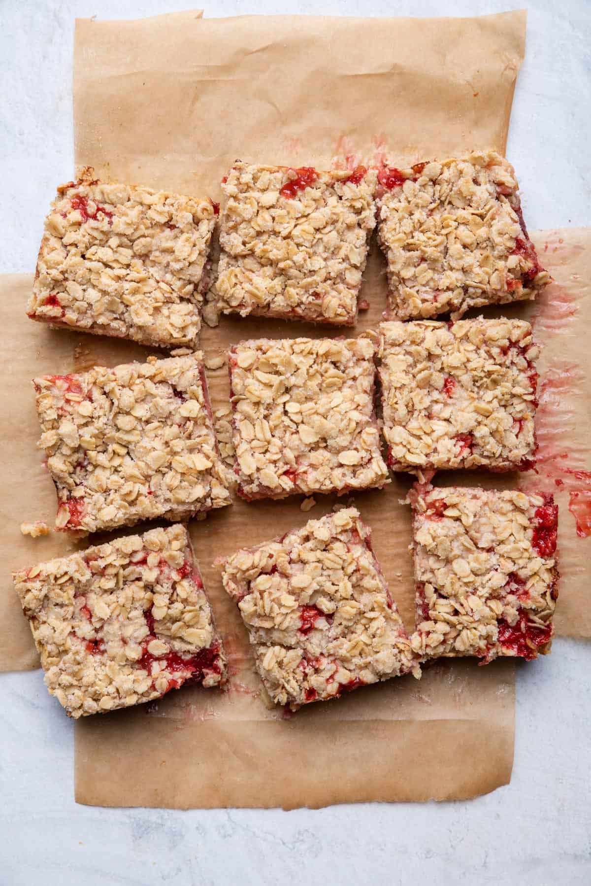 Strawberry oat bars after baking on parchment paper cut into 9 bars