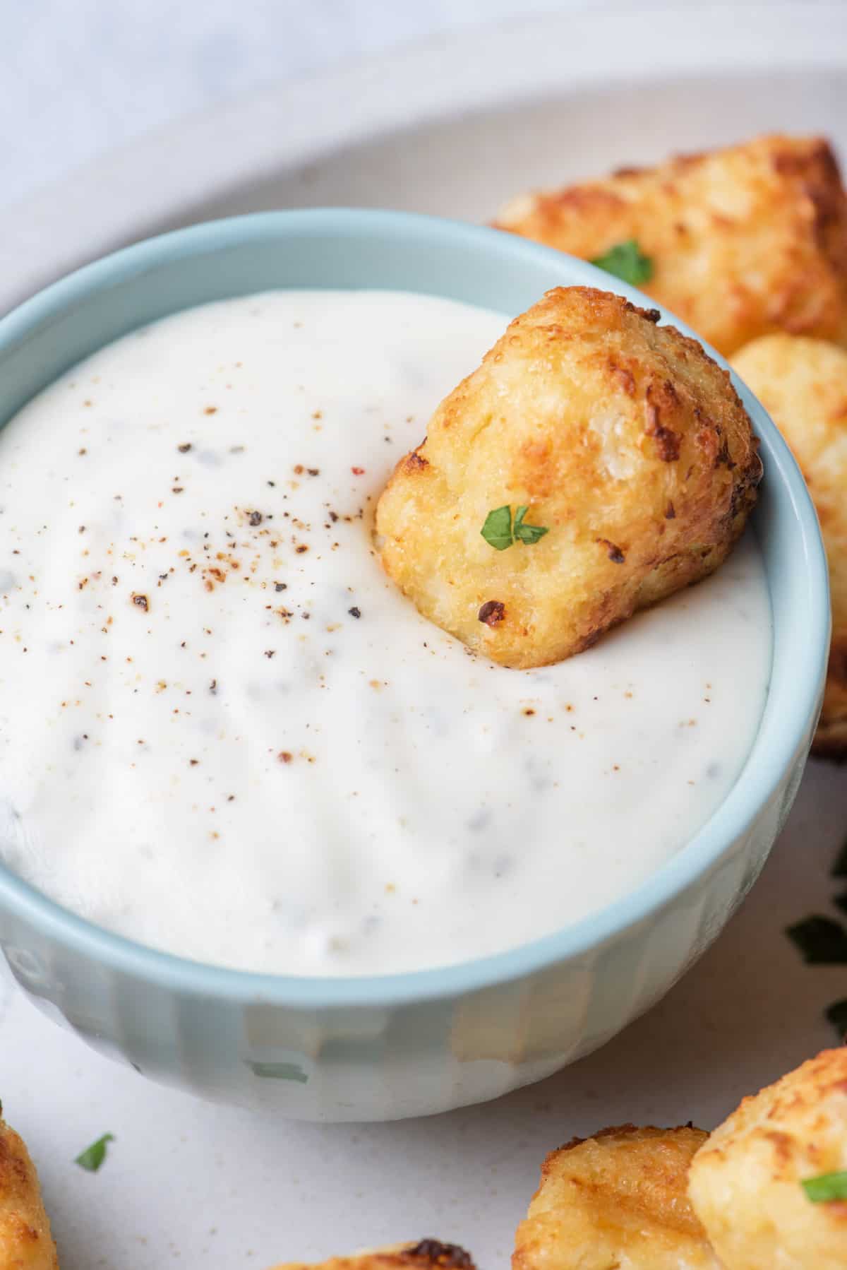 Cauliflower tater tot dipped into ranch dressing