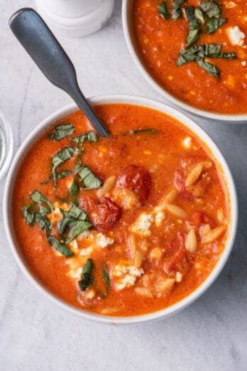 Large bowl of baked feta soup with spoon inside