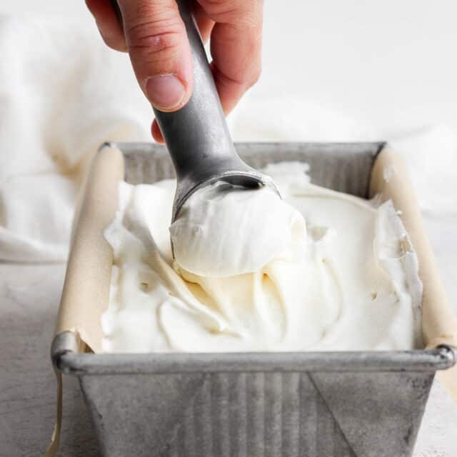 Ice cream scooper scooping homemade ice cream from a loaf pan