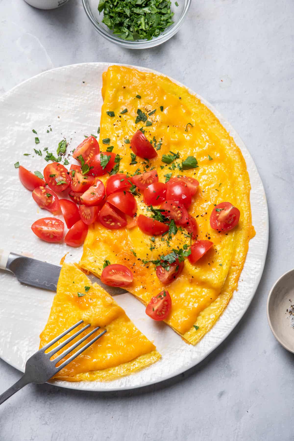 Inside out omelette served on a plate cut with fork and knife