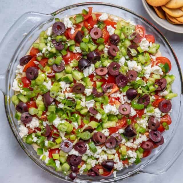 7 layer mediterranean dip with pita chips served on the side
