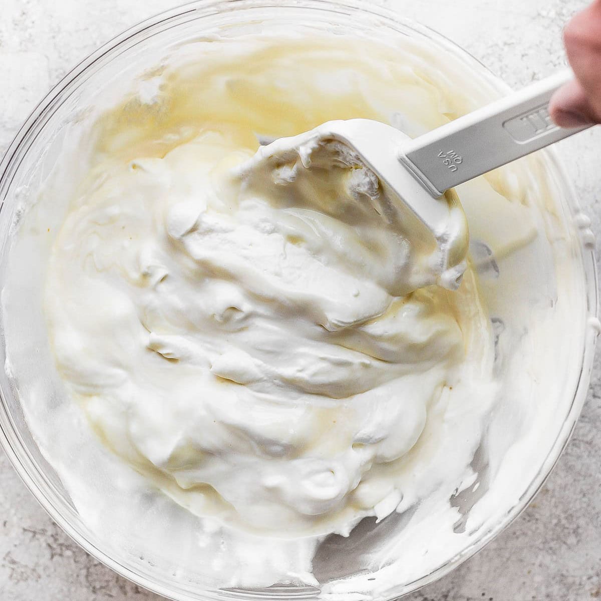 Folding half whipped cream into milk mixture.