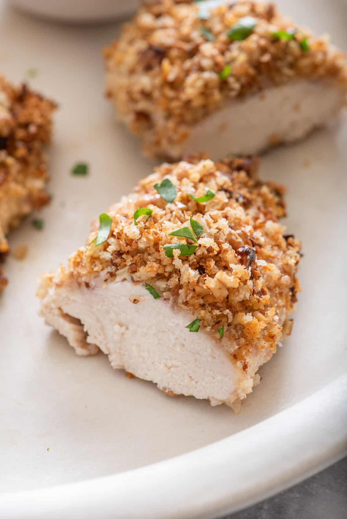 One piece of pecan crusted chicken cut in half