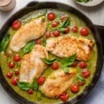 Creamy pesto chicken in a skillet with cherry tomatoes