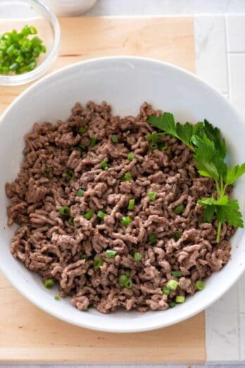 Cooked ground beef from instant pot in bowl with parsley