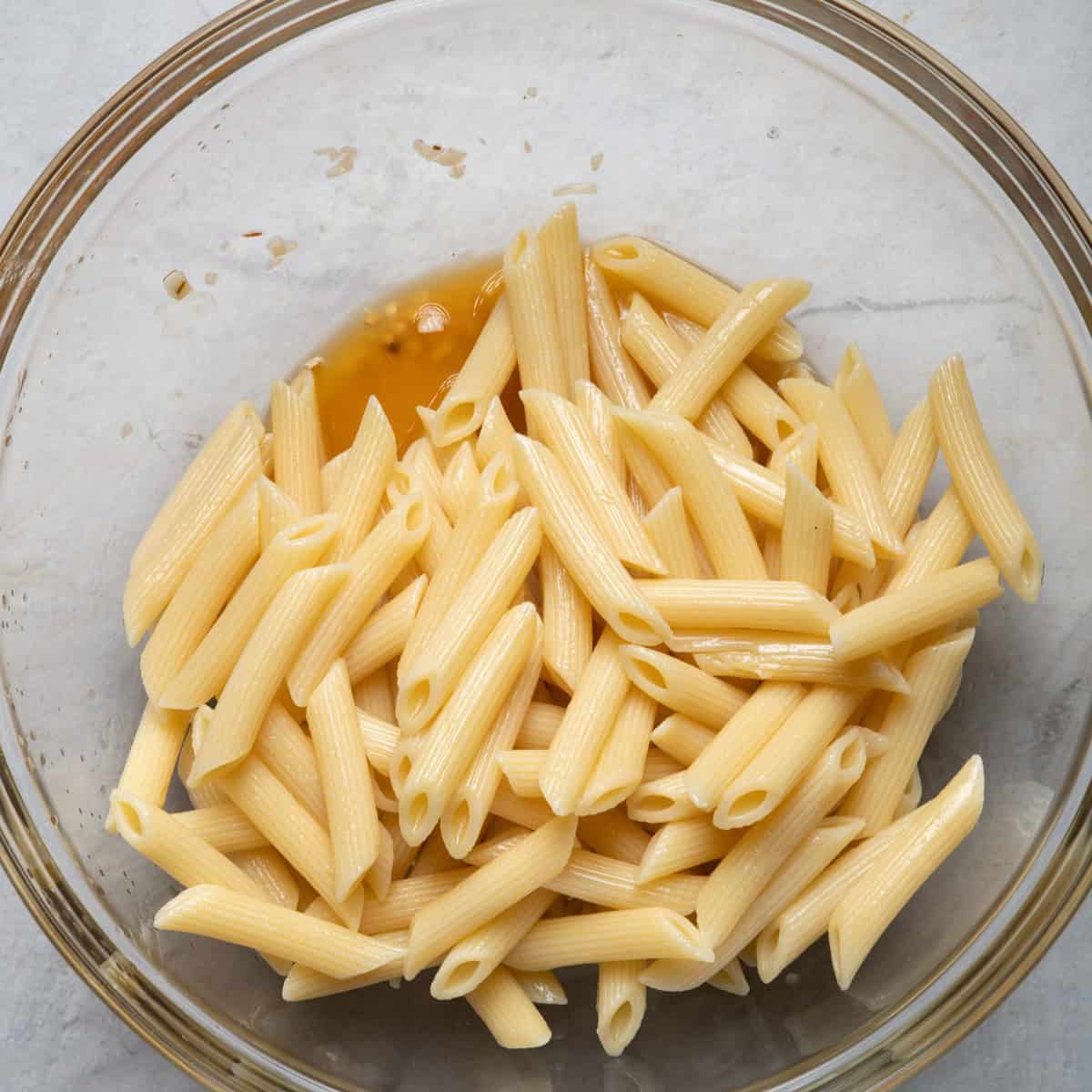Pasta on top of salad dressing.