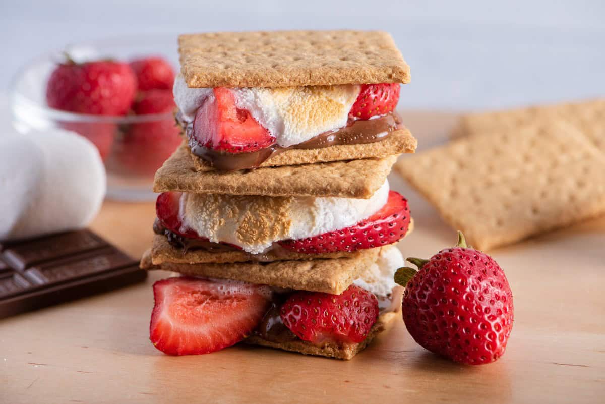 Stack of s’mores with ingredients nearby.