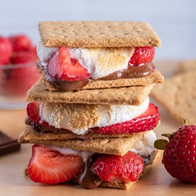 Stack of s’mores with ingredients nearby.