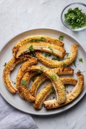 Plate of corn ribs served with side of cilantro