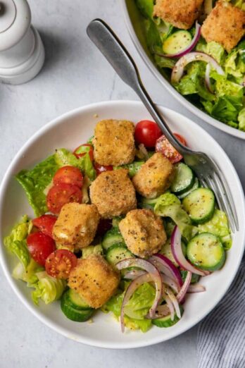 Small bowl of crispy feta croutons on top of salad