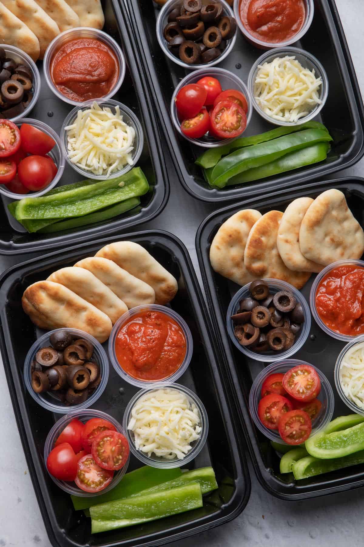 DIY Pizza lunchable meal prep with sauce, cheese, tomatoes, olives and peppers