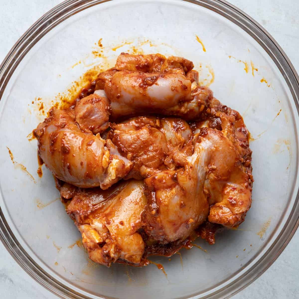 Chicken and spice mix combined in the bowl.