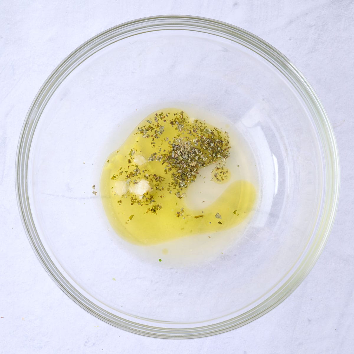 Lemon juice, oil, garlic, oregano, and salt in a large bowl.