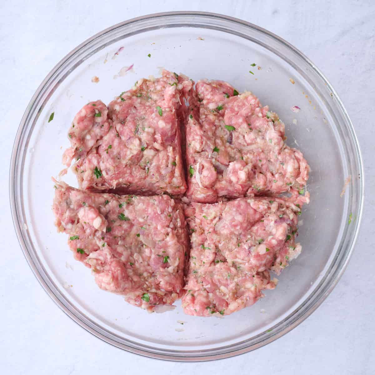 The meat in a bowl divided into four equal sections.