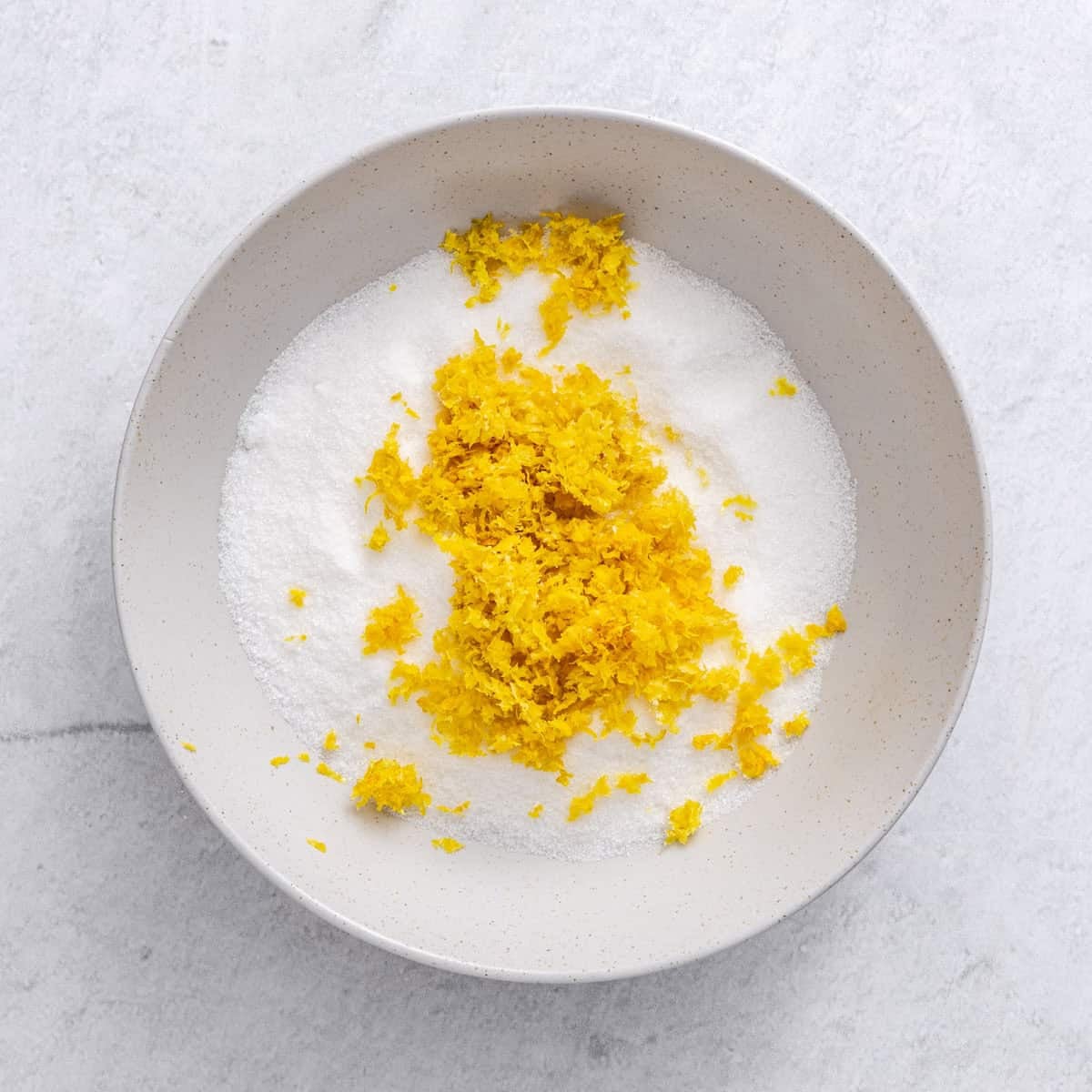 Sugar and lemon zest in a bowl.