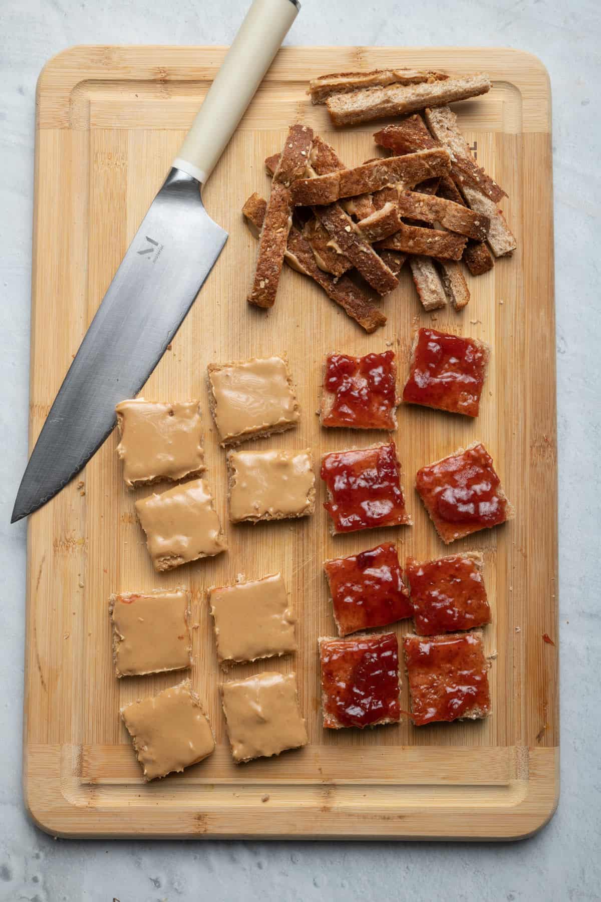 Cutting board showing the peanut butter slice and jelly slice cut into 8 pieces