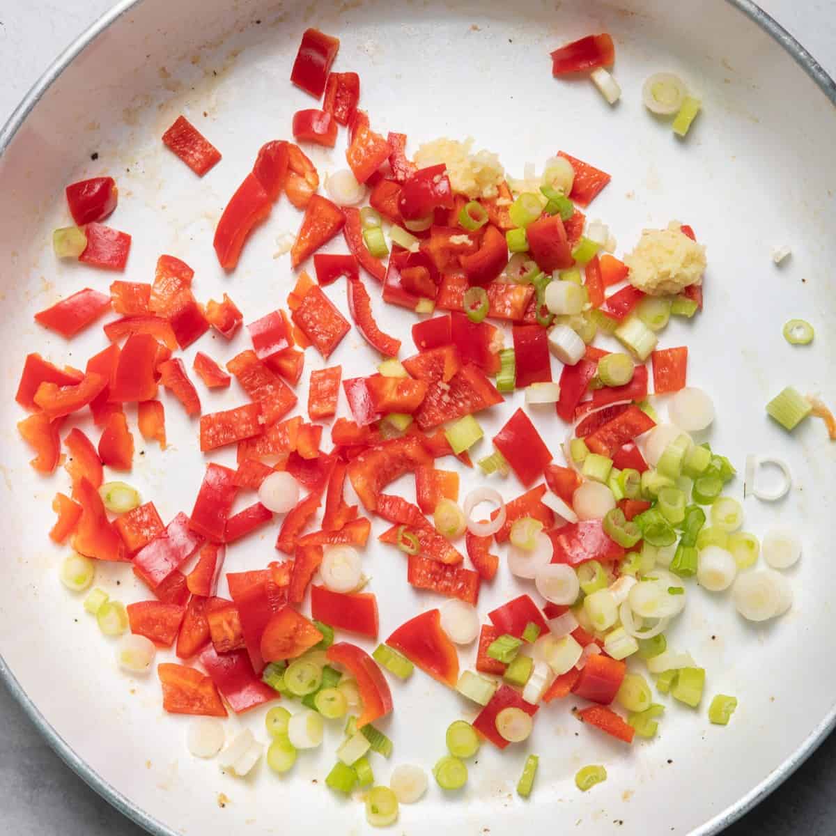 Uncooked scallions, peppers and carrots.