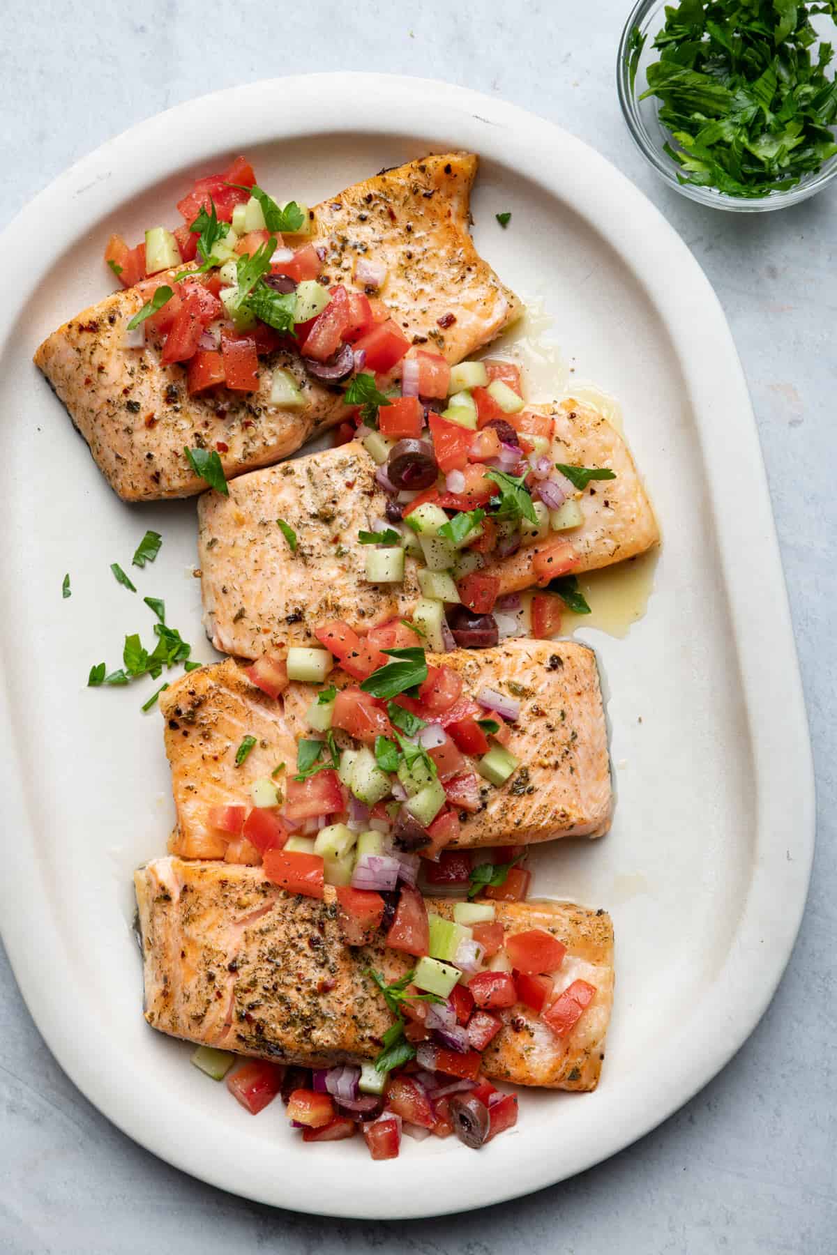 Air fryer Greek salmon on a platter served with greek salad