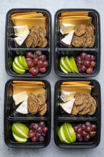 Meal prep containers with cheese, fruit and crackers