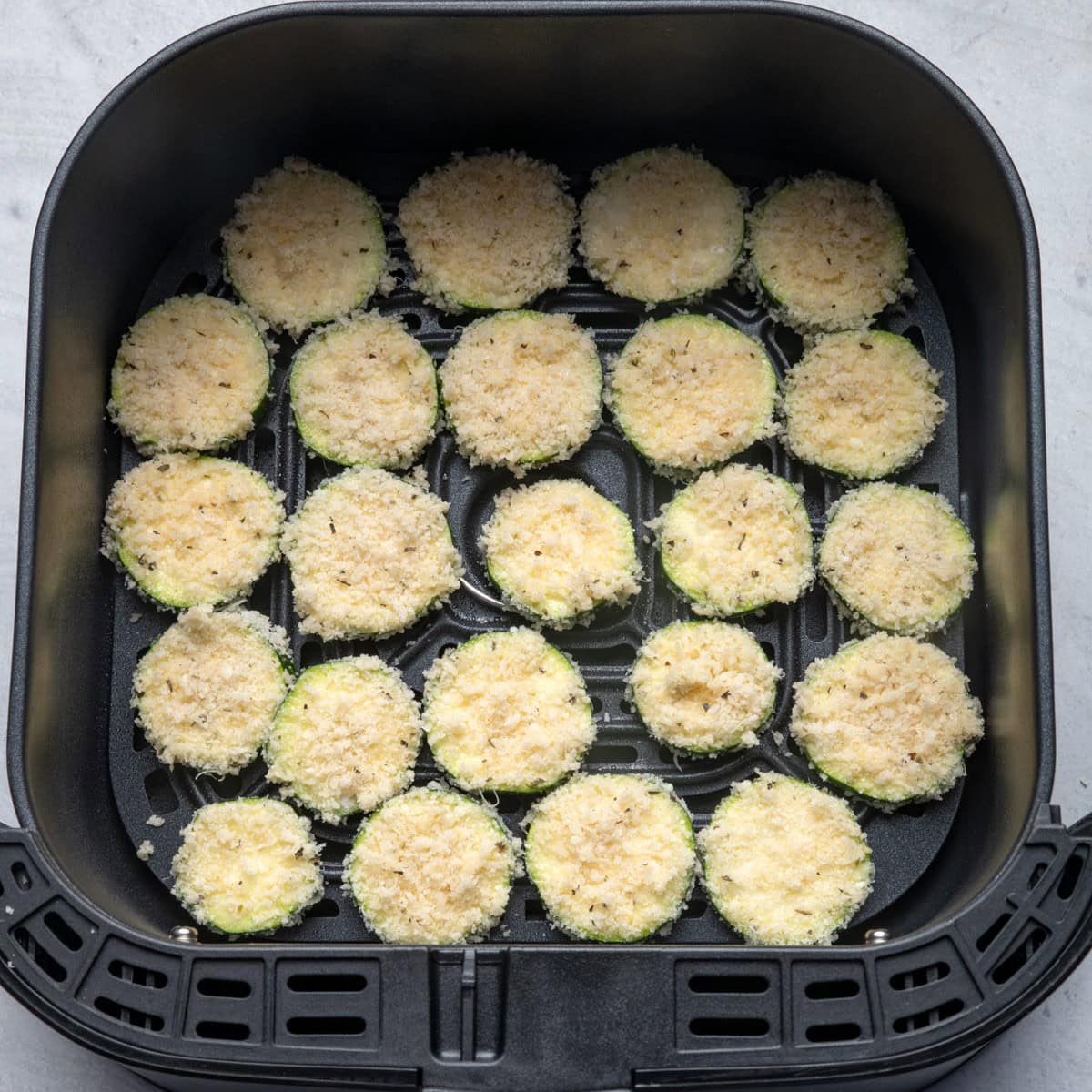 Zucchini in air fryer basket before cooked.