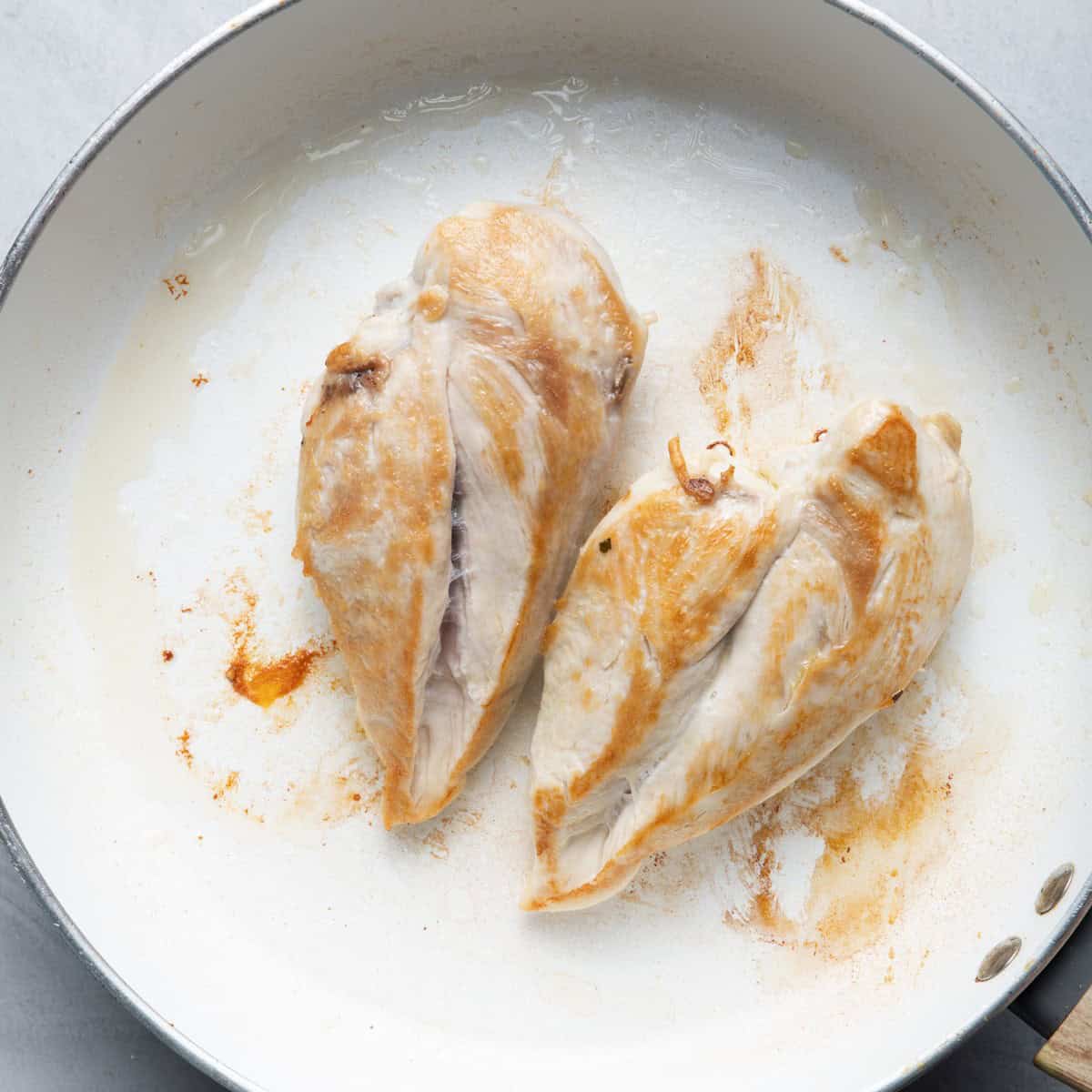 Cooked chicken on skillet.