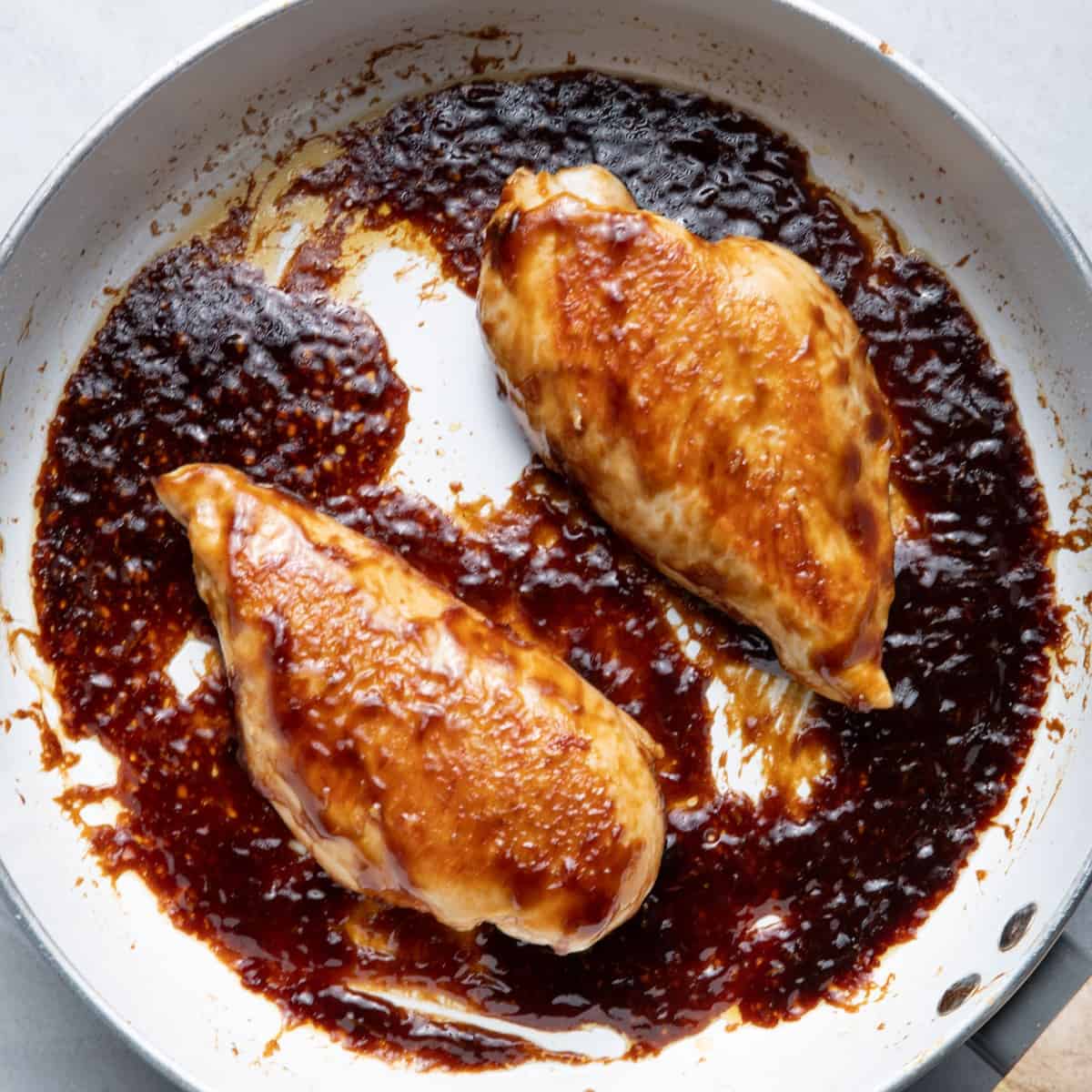Reduced sauce with chicken in the skillet.