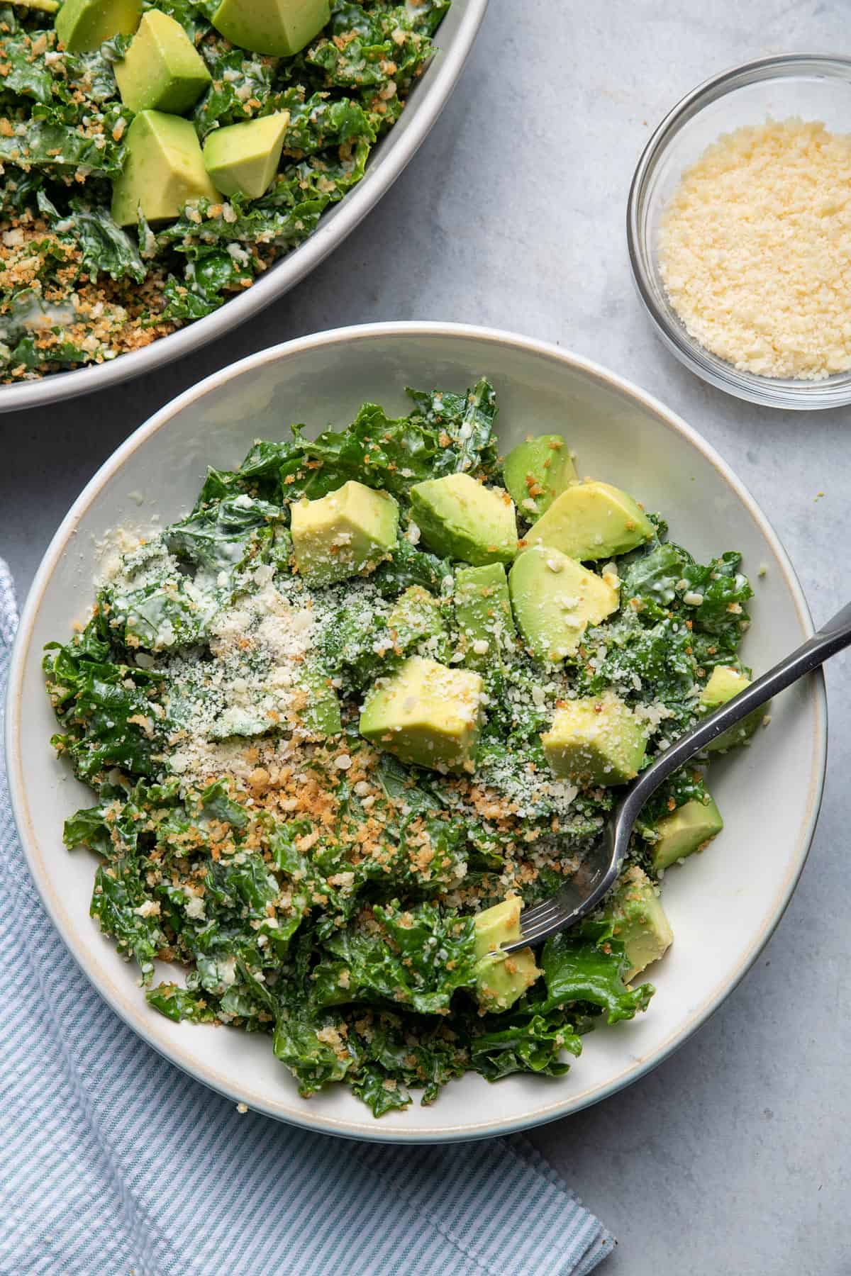 Kale Caesar Salad in a bowl served with avocados on top