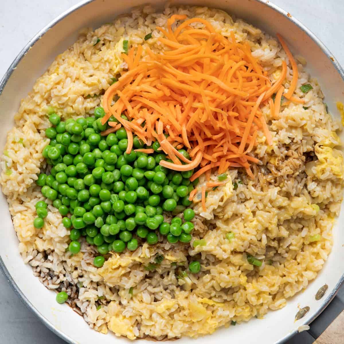Show carrots, peas, soy sauce and sesame oil on top.