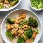 Shrimp and broccoli stir fry in bowls over brown rice