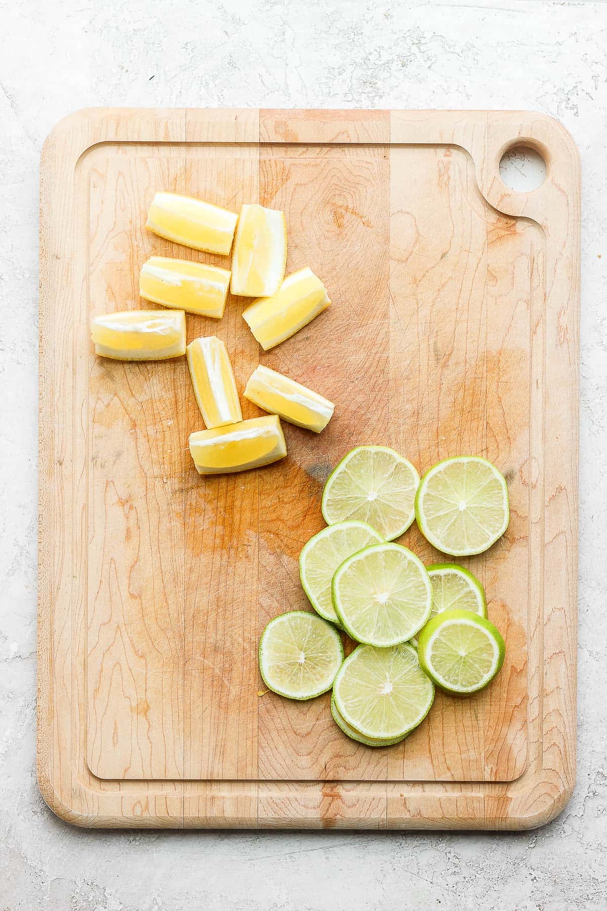 Cutting board with lemon wedges and lime slices